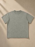 Unisex bamboo slub snow washed t-shirt in Bean Green, laid flat on pale limestone