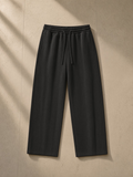 Waffle barrel leg pants in Black, laid flat on pale limestone