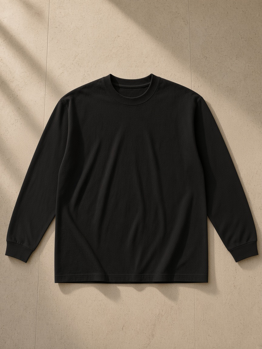 Essential Cotton Long Sleeve T-Shirt in Black, laid flat on pale limestone