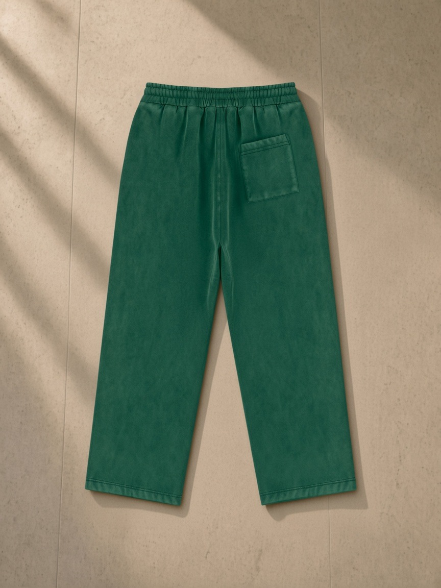 Vintage Wash Fleece Sweatpants in Dark Green, laid flat on pale limestone, back.