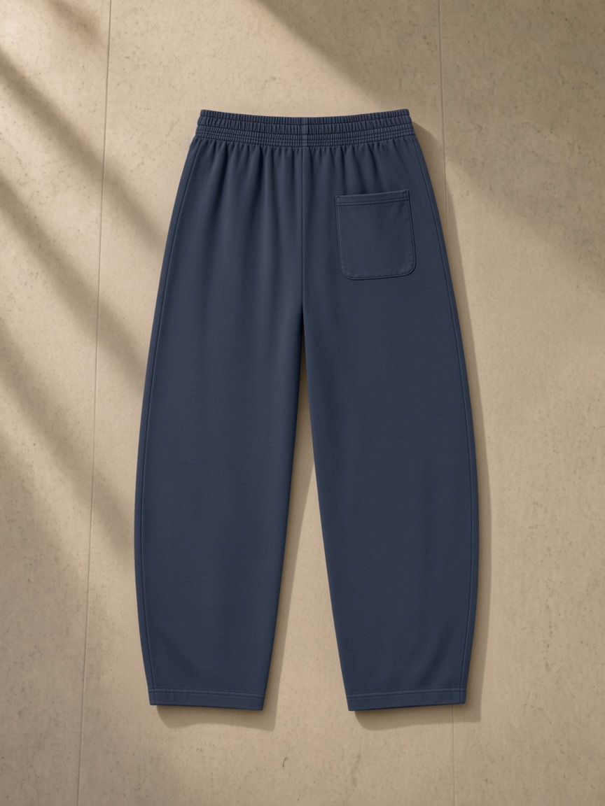 Vintage Washed Barrel Leg Sweatpants in Navy Blue, laid flat on pale limestone, back.