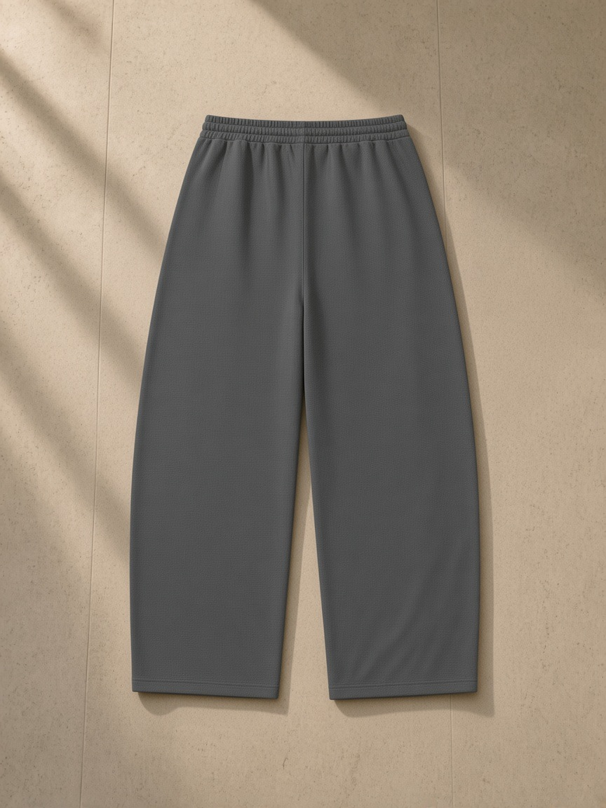 Waffle barrel leg pants in Dark Gray, laid flat on pale limestone, back view