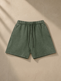 Vintage Wash Cotton Shorts in Army Green, laid flat on pale limestone