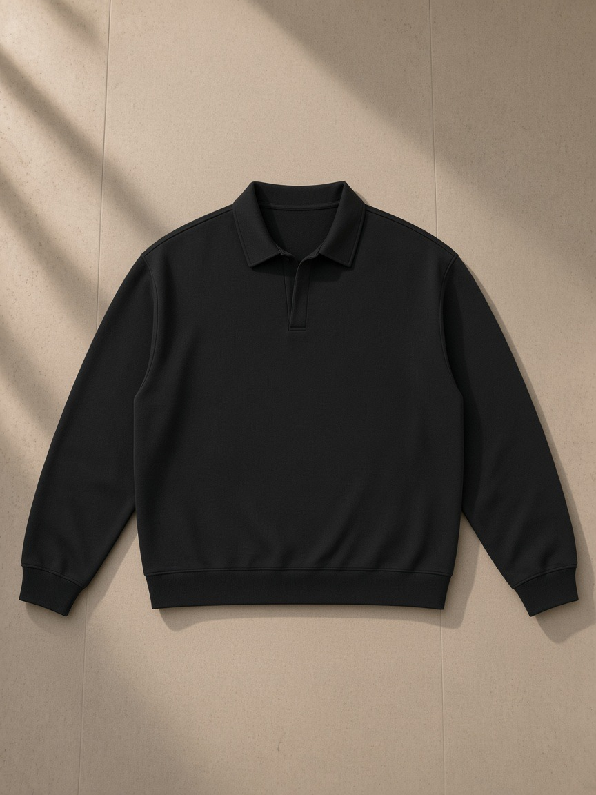 Oversized Collared Sweatshirt in Black, laid flat on pale limestone