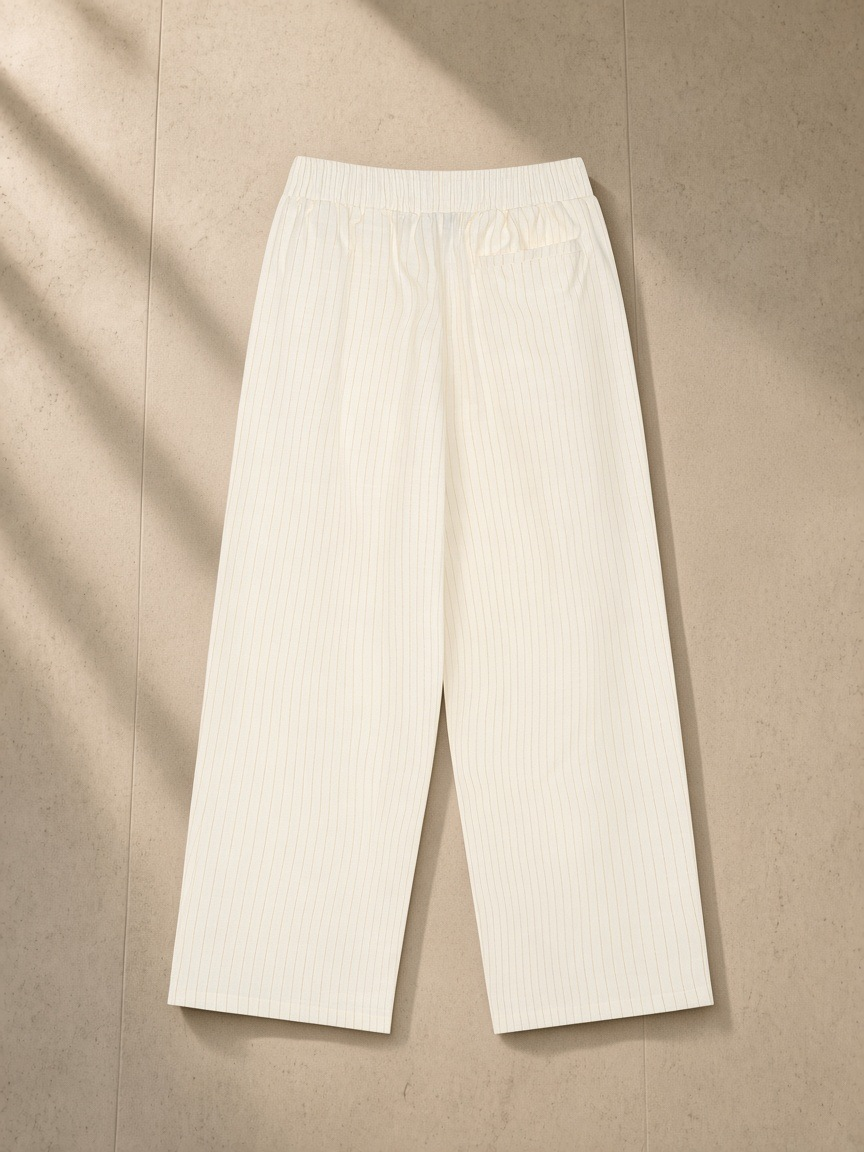 Striped Pleated Pants in White, laid flat on pale limestone, back view