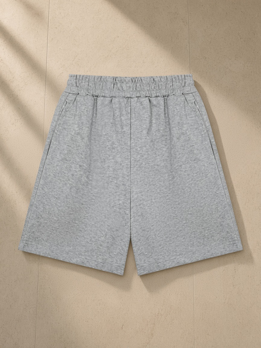 Unisex heavyweight shorts in Flower Gray, laid flat on pale limestone