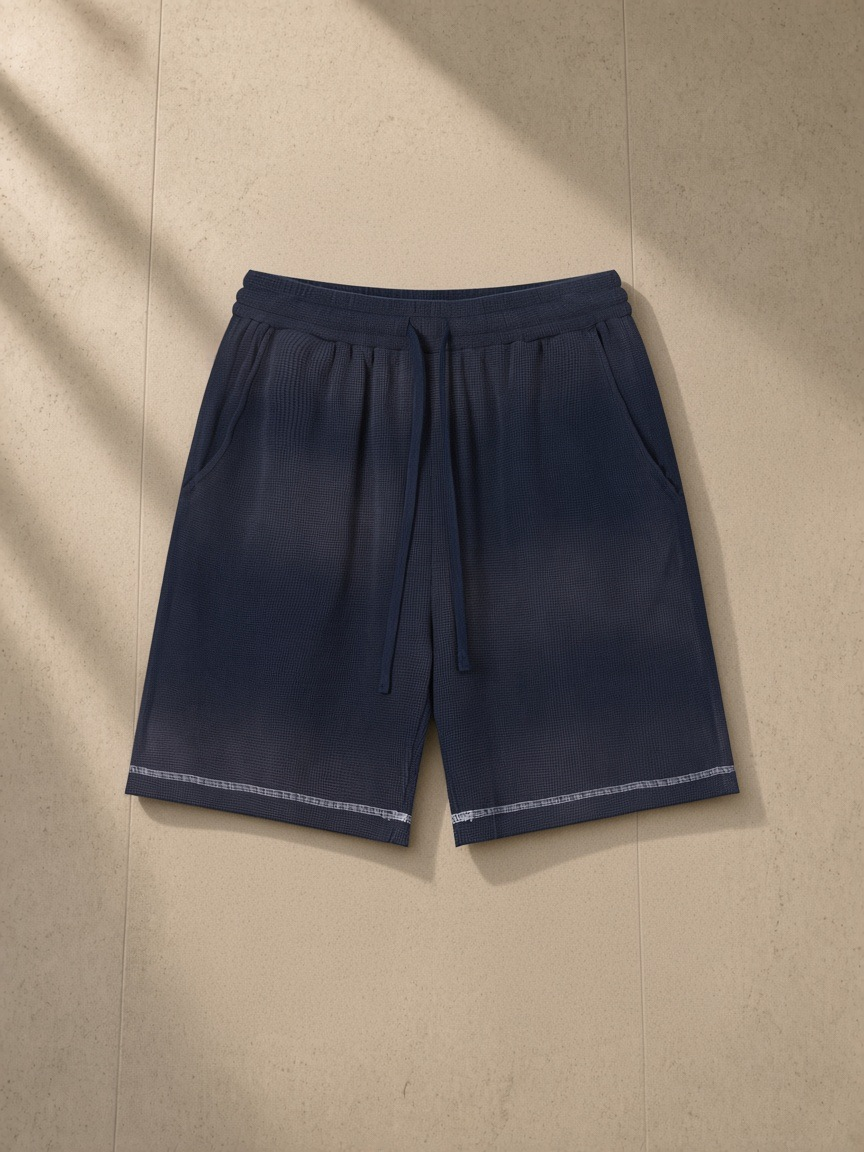 Sunfade waffle raw hem shorts in Navy Blue, laid flat on pale limestone