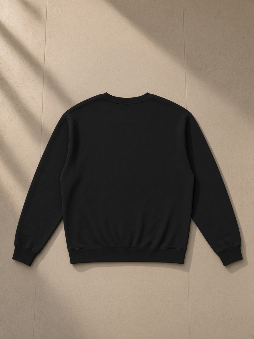 Loose Crewneck Sweatshirt in Black, laid flat on pale limestone, back view