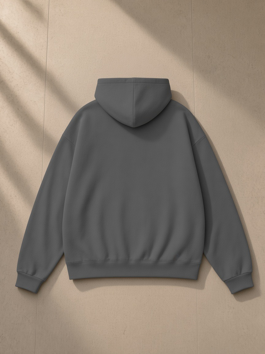 Unisex heavyweight hidden pocket fleece hoodie in Charcoal, laid flat on pale limestone, back view
