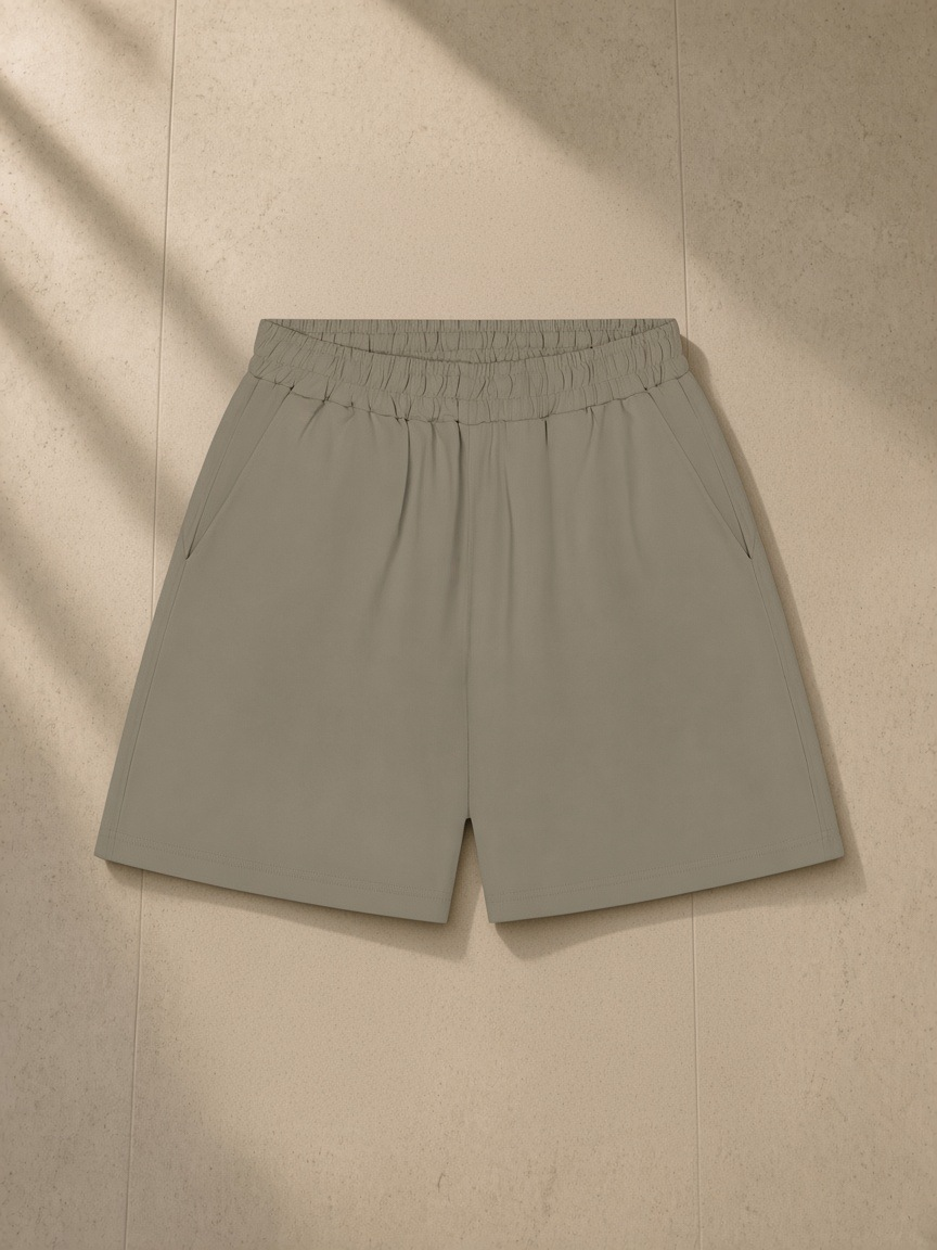 Unisex regular fit shorts in Gray Green, laid flat on pale limestone