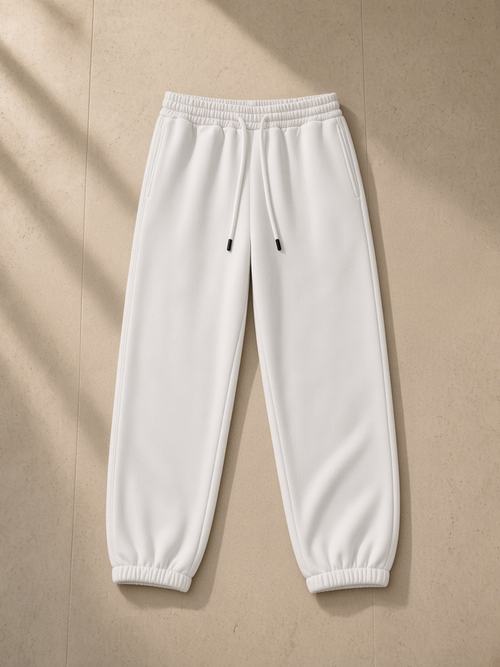 Heavyweight Fleece Joggers in White, laid flat on pale limestone