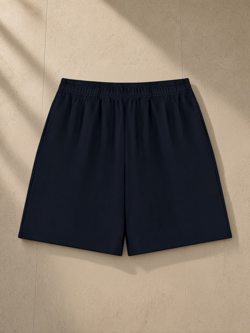 Cotton Shorts in Black, laid flat on pale limestone
