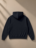 Essential Heavyweight Drop-Shoulder Hoodie in Navy Blue, laid flat on pale limestone, back view