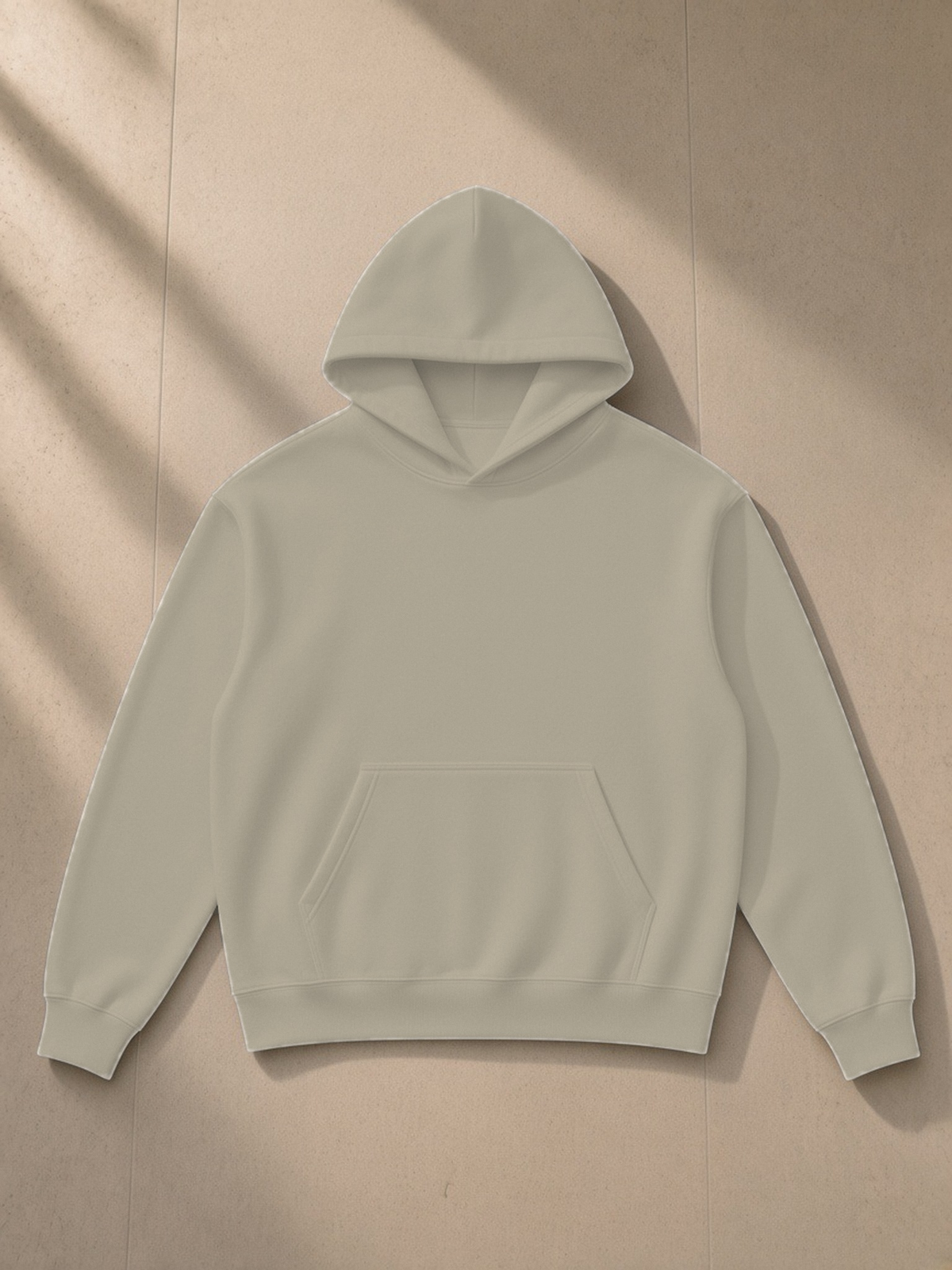 Essential Heavyweight Drop-Shoulder Hoodie in Light Gray, laid flat on pale limestone, front.