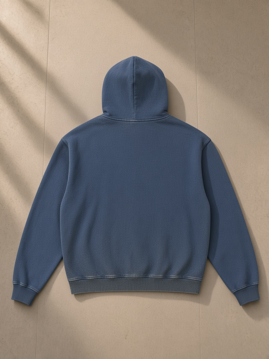 Vintage washed gradient fleece hoodie in Navy Blue, laid flat on pale limestone, back view
