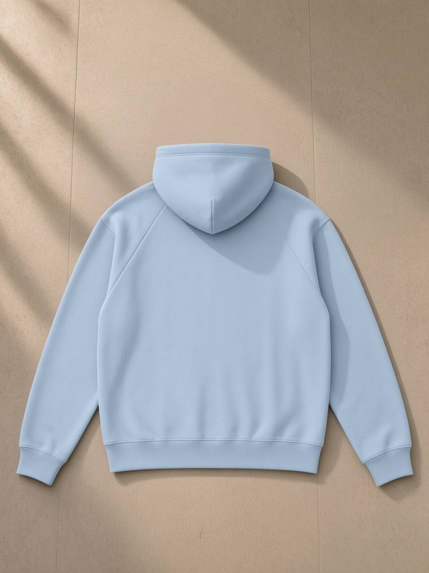 Unisex heavyweight raglan sleeve zip hoodie in Blue, laid flat on pale limestone, back view