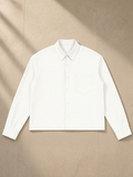 Button-Front Long Sleeve Shirt in White, laid flat on pale limestone