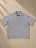 Heavyweight Snow-Washed Polo in Light Gray, laid flat on pale limestone