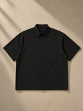 Boxy Short Sleeve Shirt in Black, laid flat on pale limestone