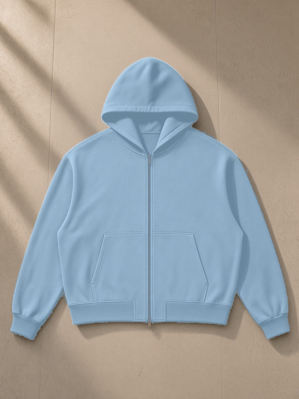 Vintage Wash Boxy Full Zip Hoodie in Haze Blue, laid flat on pale limestone, front view
