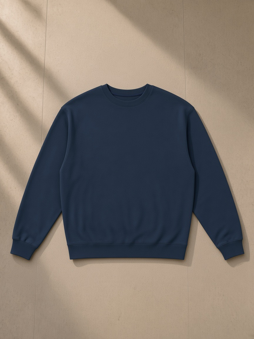 Loose Crewneck Sweatshirt in Navy Blue, laid flat on pale limestone, front.