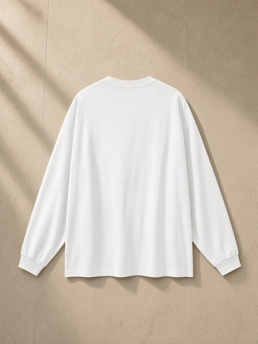 Oversized Long Sleeve T-Shirt in White, laid flat on pale limestone, back view