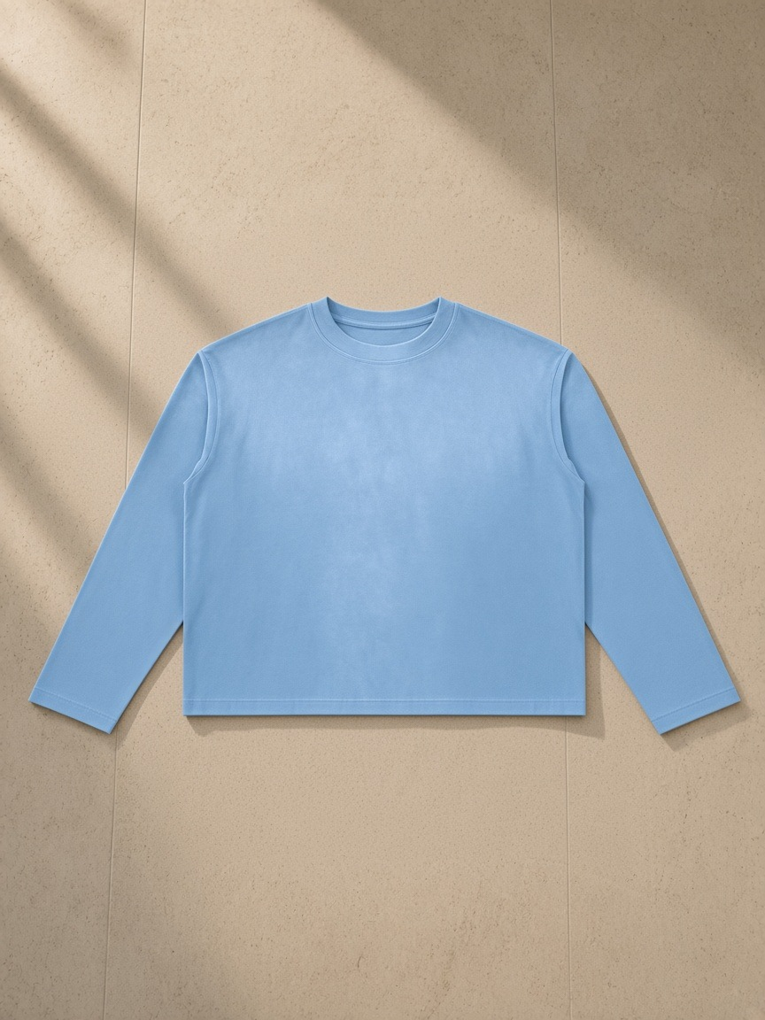 Sunfade boxy long sleeve t-shirt in Sky Blue, laid flat on pale limestone