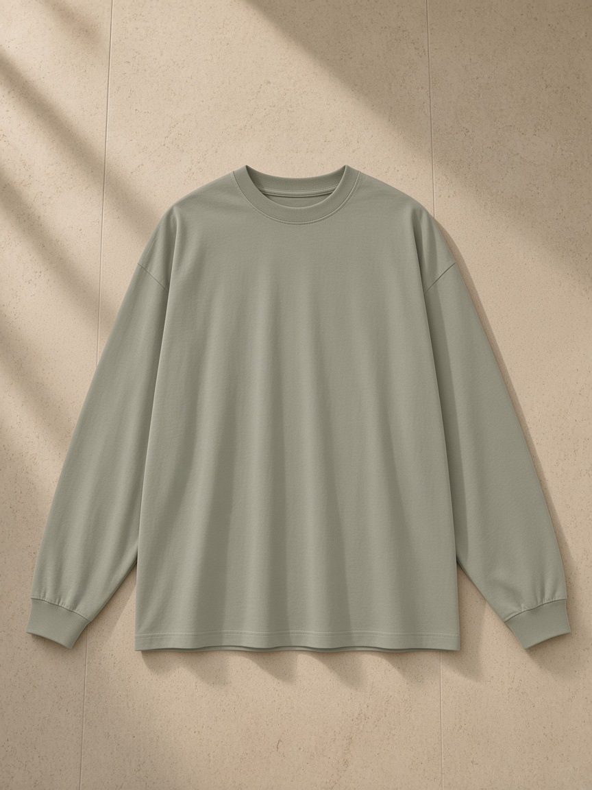 Oversized Long Sleeve T-Shirt in Gray Green, laid flat on pale limestone