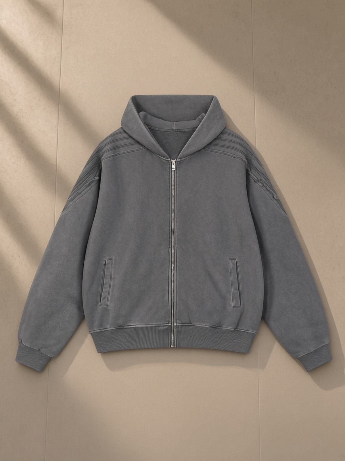 Snow Washed Tape Raw Edge Zip Hoodie in Dark Gray, laid flat on pale limestone, front view