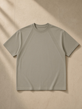 Tonal Paneled Performance T-Shirt in Gray Green, laid flat on pale limestone