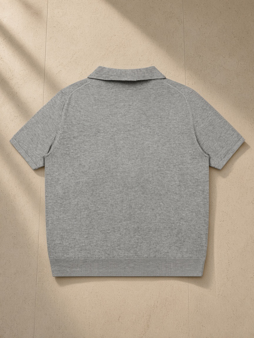 Heavyweight Oversized Polo in Flower Gray, laid flat on pale limestone, back view