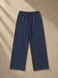 Heavyweight Fleece Sweatpants in Navy Blue, laid flat on pale limestone