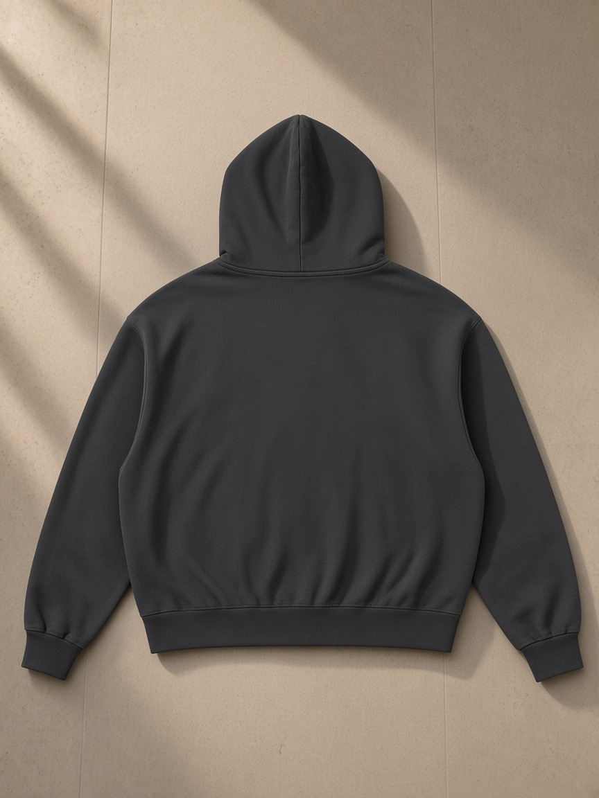 Boxy Oversized Hoodie in Black, laid flat on pale limestone, back view