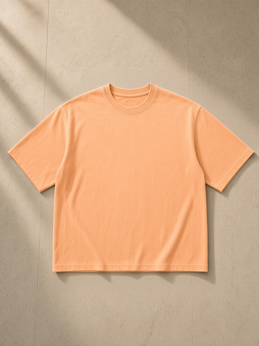 Vintage Wash Sunfade Boxy T-Shirt in Apricot, laid flat on pale limestone