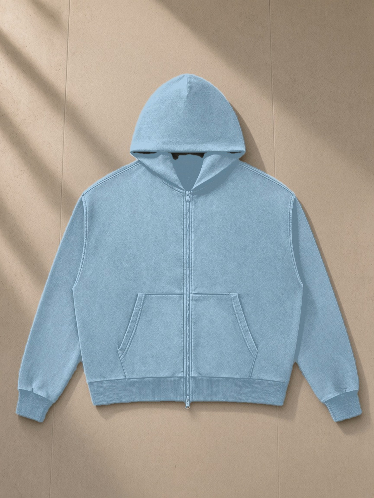 Mineral Wash Boxy Full Zip Hoodie in Haze Blue, laid flat on pale limestone, front view