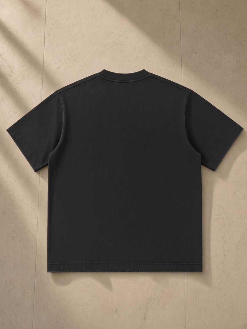 Women's Heavyweight Vintage Washed Frayed T-Shirt in Black, laid flat on pale limestone, back.