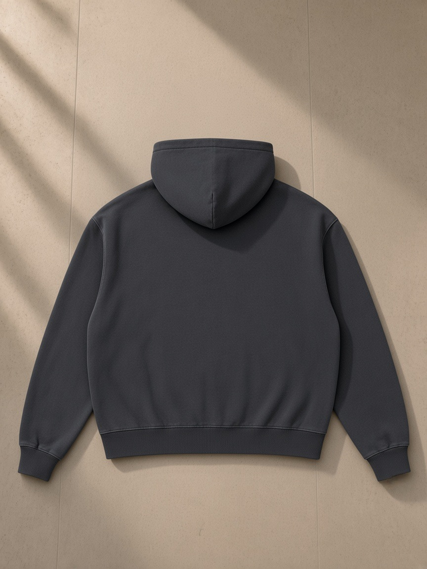 Mineral Wash Boxy Hoodie in Dark Gray, laid flat on pale limestone, back view