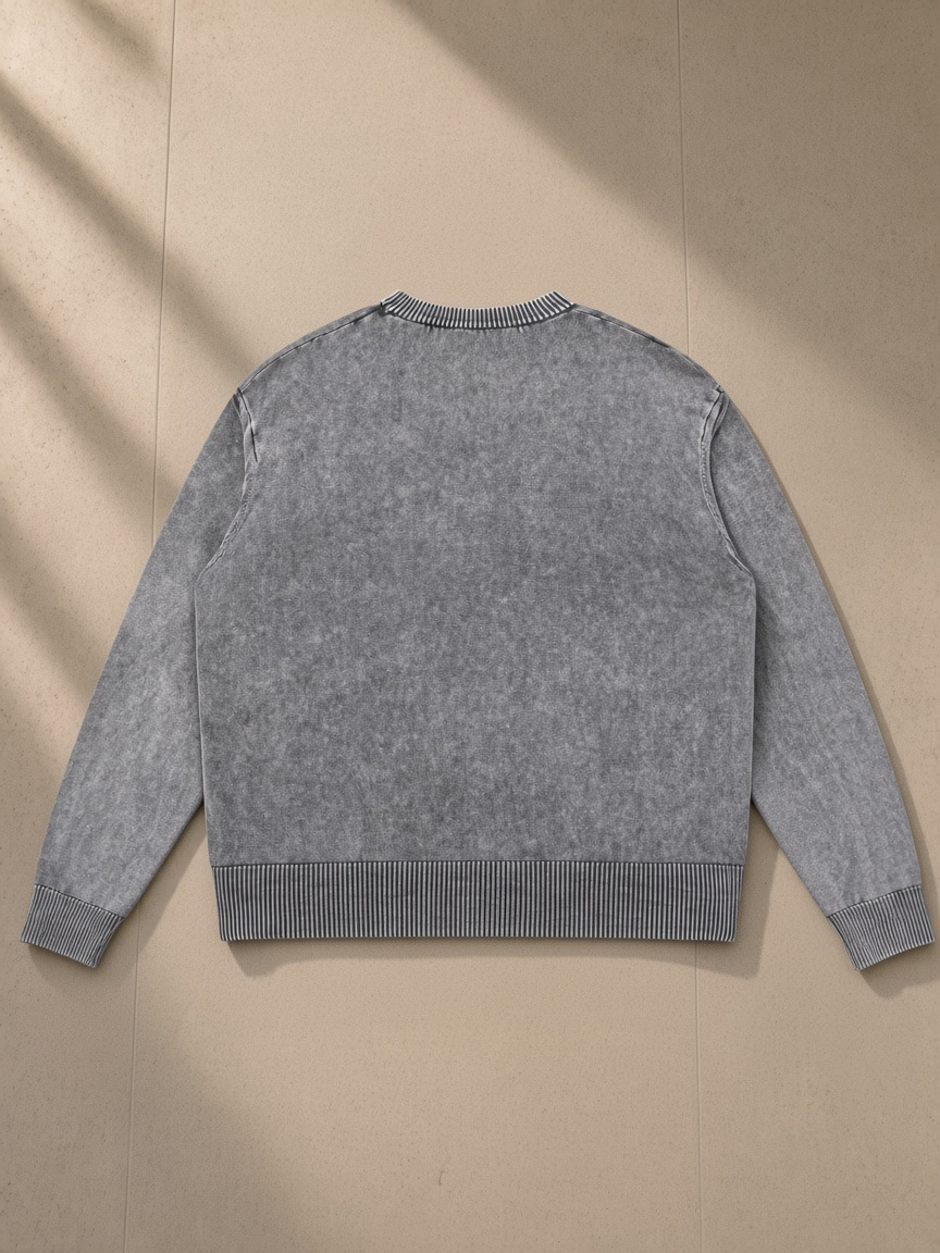 Mineral Wash Crewneck Sweater in Gray, laid flat on pale limestone, back view