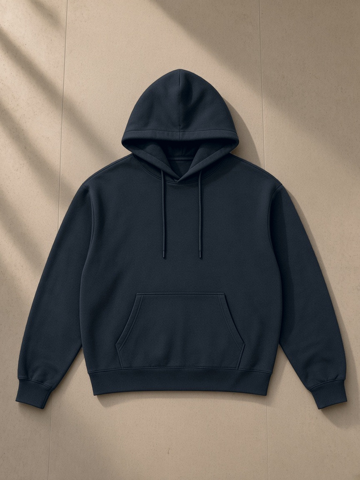 Relaxed Fit Hoodie in Navy Blue, laid flat on pale limestone, front view