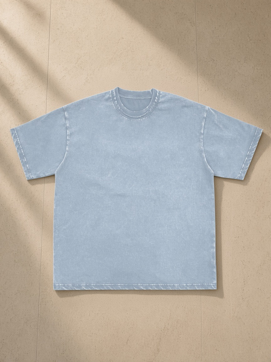 Snow washed raw-edge neckline t-shirt in Blue, laid flat on pale limestone