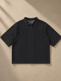 Vintage Wash Lyocell Shirt in Black, laid flat on pale limestone