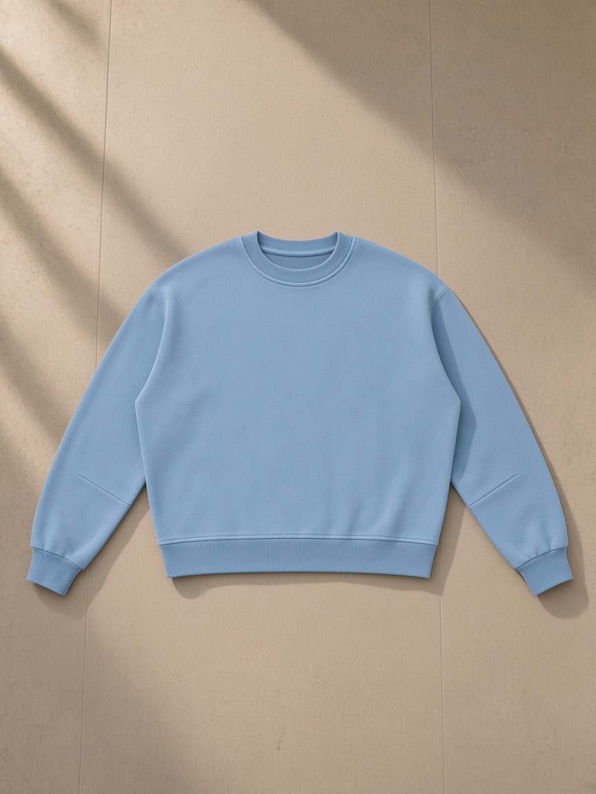 Boxy Vintage Washed Sweatshirt in Light Blue, laid flat on pale limestone