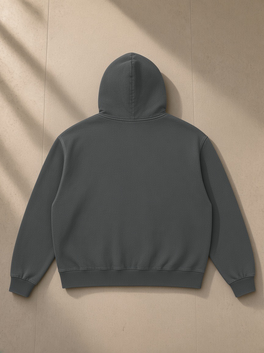 Heavyweight Vintage Wash Boxy Hoodie in Dark Gray, laid flat on pale limestone, back view