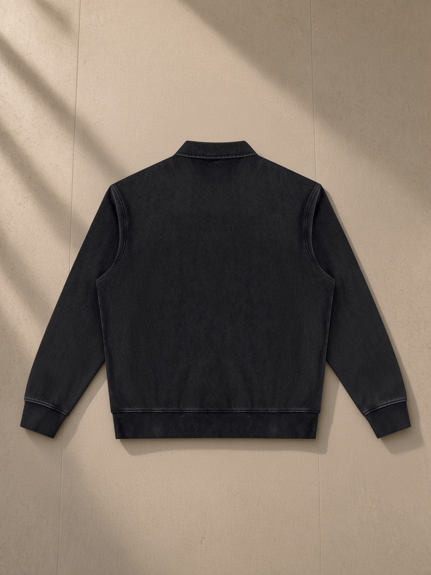 Vintage wash quarter-zip sweatshirt in Black, laid flat on pale limestone, back view