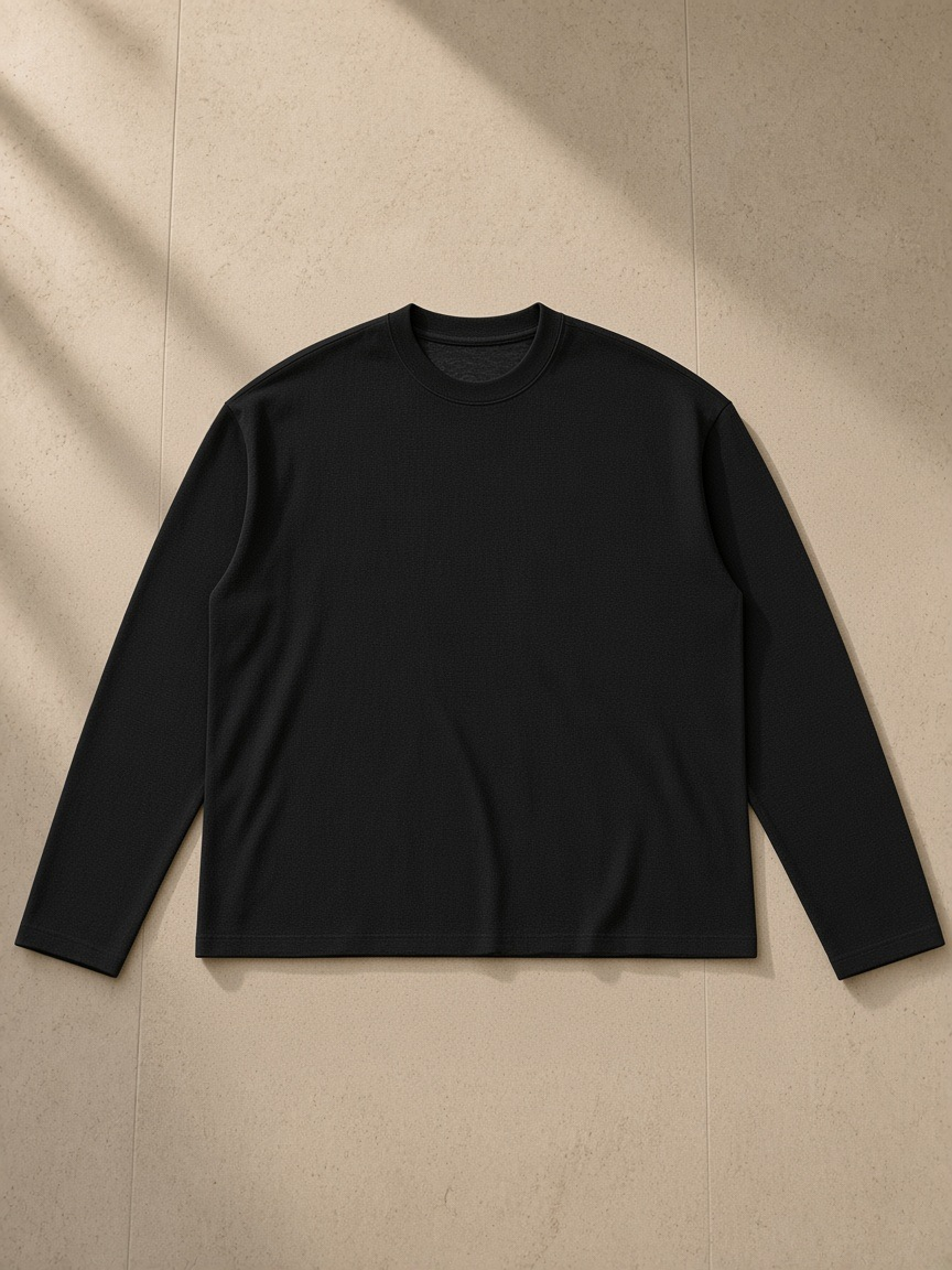 Raw Edge Long Sleeve T-Shirt in Black, laid flat on pale limestone