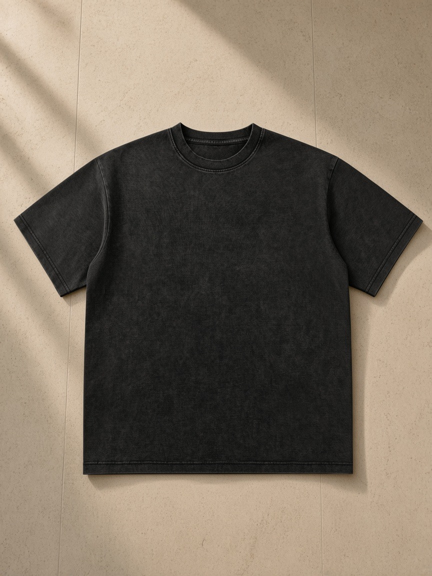 Unisex bamboo slub snow washed t-shirt in Black, laid flat on pale limestone