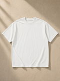 Unisex vintage wash distressed t-shirt in Oat Gray, laid flat on pale limestone