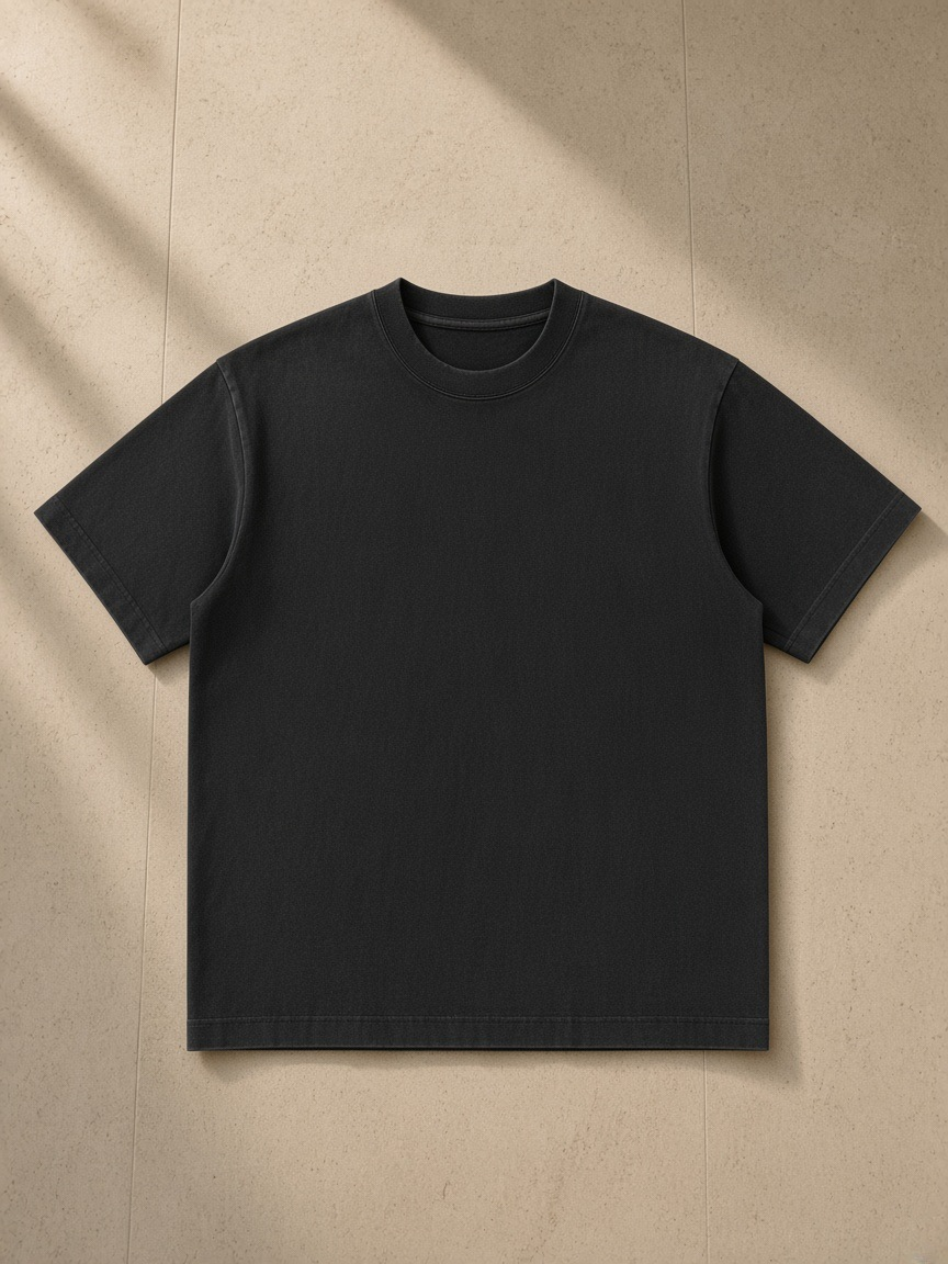 Men's heavyweight vintage washed frayed t-shirt in Black, laid flat on pale limestone