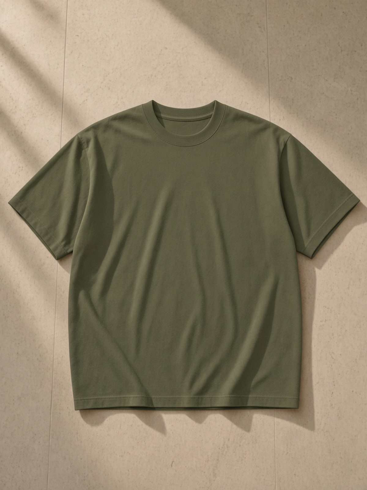 Oversized Drop Shoulder T-Shirt, 200 gsm in Army Green, laid flat on pale limestone, front.