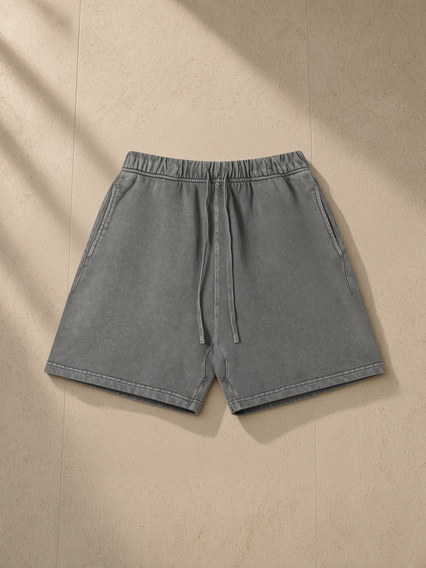Vintage Wash Cotton Shorts in Dark Gray, laid flat on pale limestone